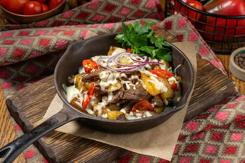Горячая сковородка с говядиной или кониной с картофелем и сыром